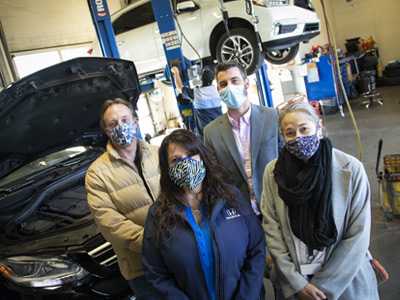 Four faculty members standing in automotive classroom